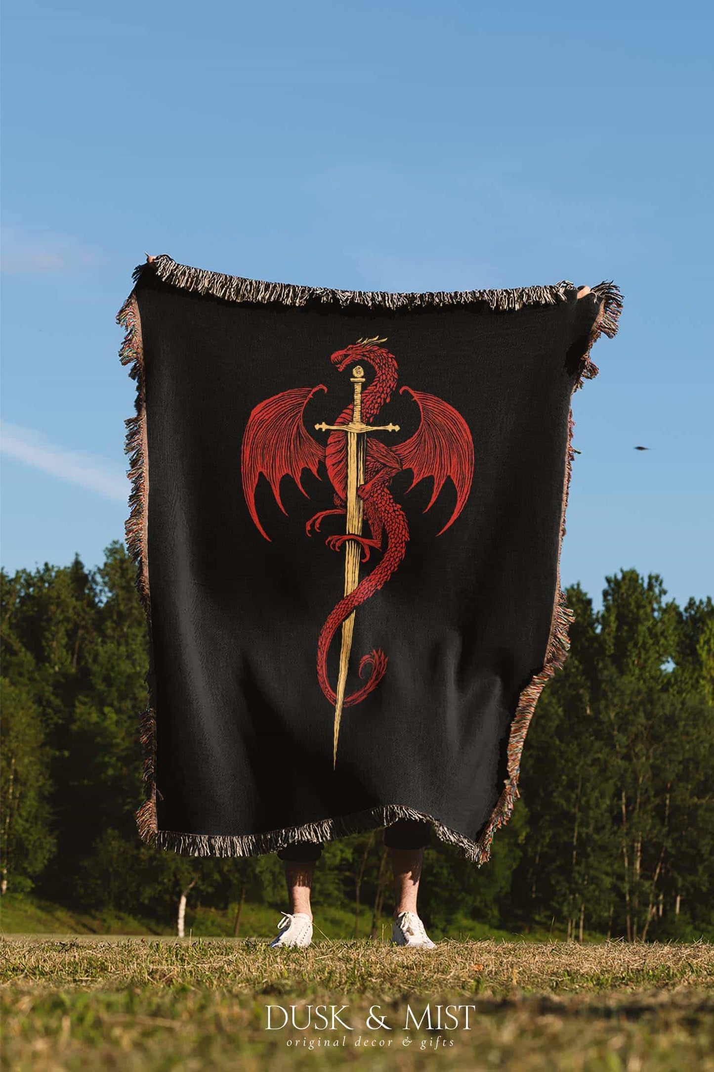 Woven cotton blanket featuring a red dragon wrapped around a golden sword on a black background with intricate wing and scale details.