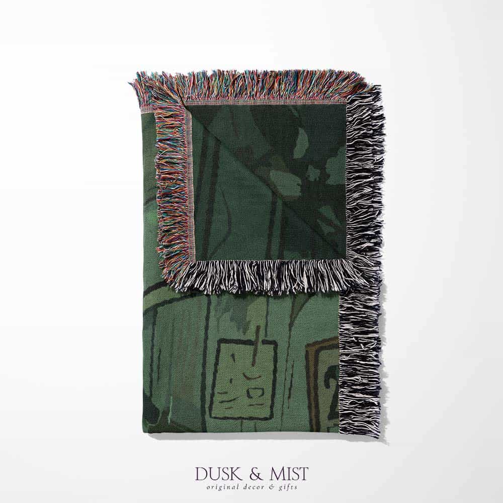 Woven cotton blanket depicting a small ghost and a young girl standing in a warmly lit wooden room filled with plants, books, and soft evening light streaming through a door.