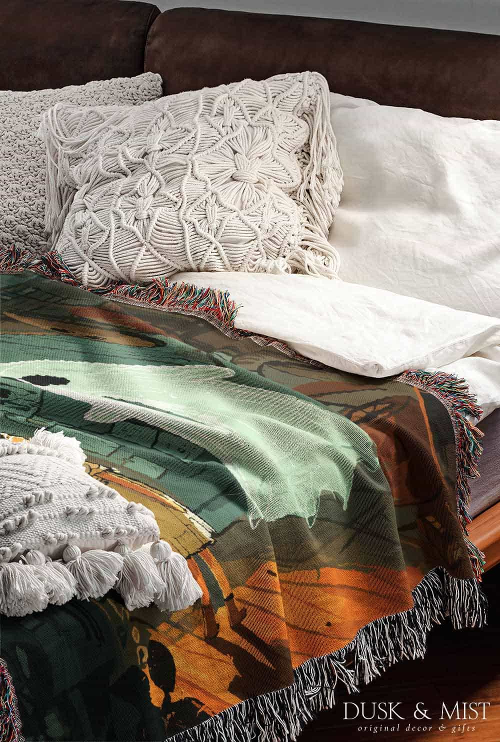 Woven cotton blanket depicting a small ghost and a young girl standing in a warmly lit wooden room filled with plants, books, and soft evening light streaming through a door.