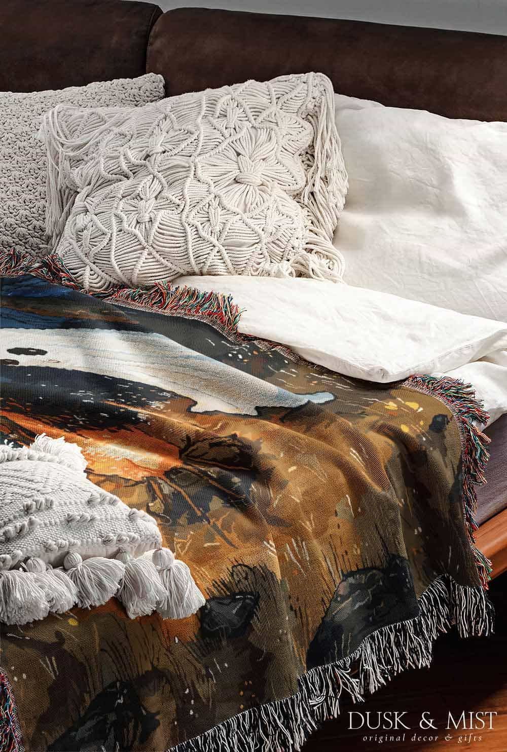 Woven cotton blanket featuring a witch and a ghost sitting by a campfire under a crescent moon in a dark forest setting.