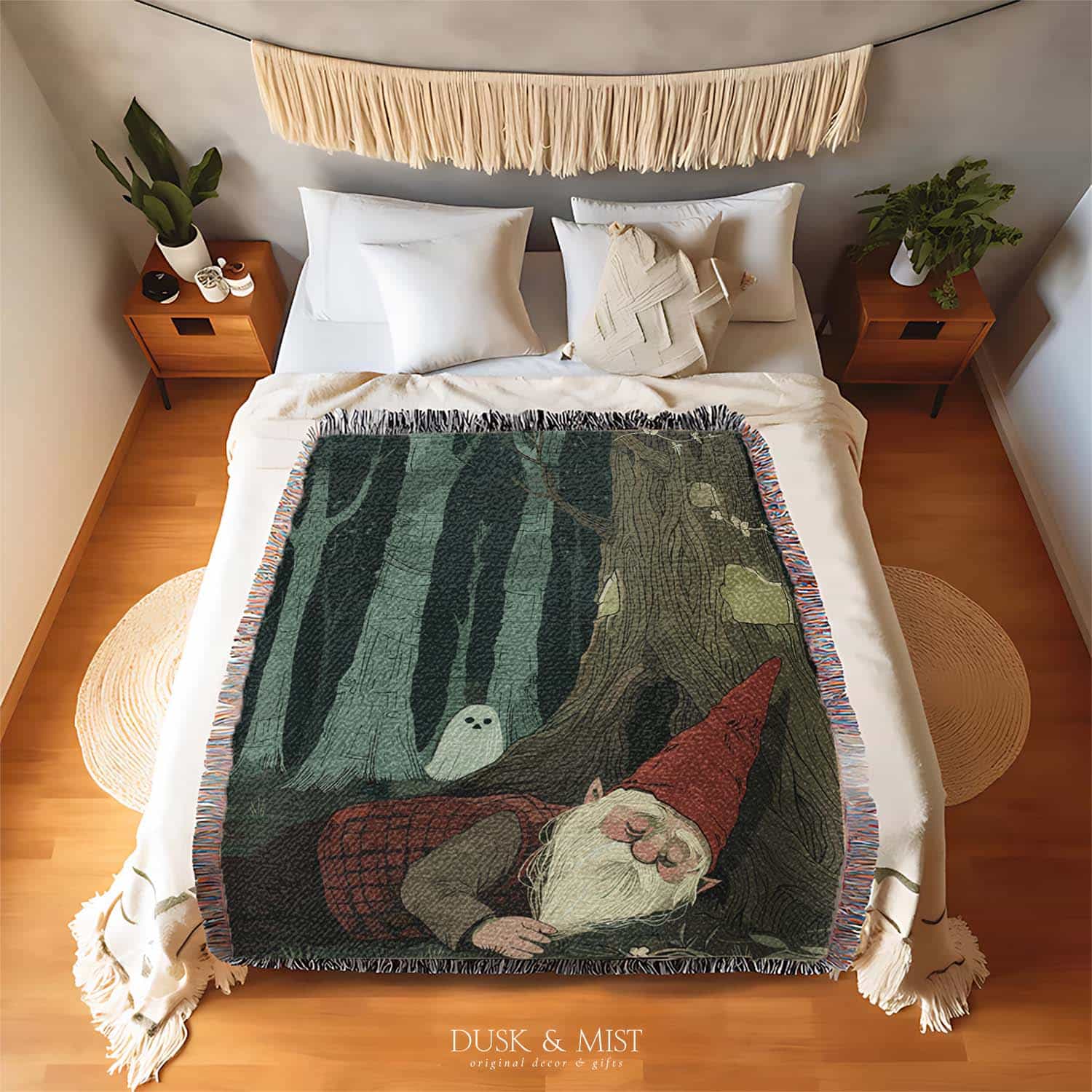 Woven cotton blanket depicting a sleeping gnome under a large tree, with a small ghost-like forest spirit in the background surrounded by dark green woods.