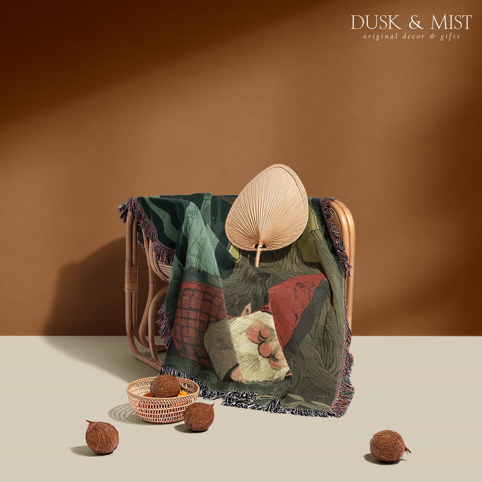 Woven cotton blanket depicting a sleeping gnome under a large tree, with a small ghost-like forest spirit in the background surrounded by dark green woods.