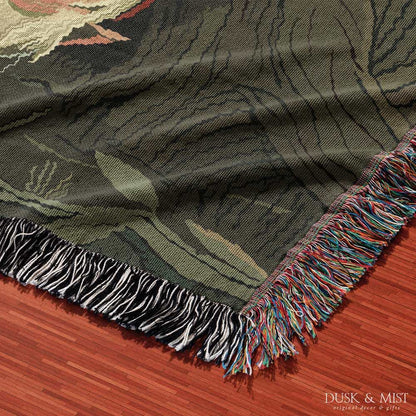 Woven cotton blanket depicting a sleeping gnome under a large tree, with a small ghost-like forest spirit in the background surrounded by dark green woods.
