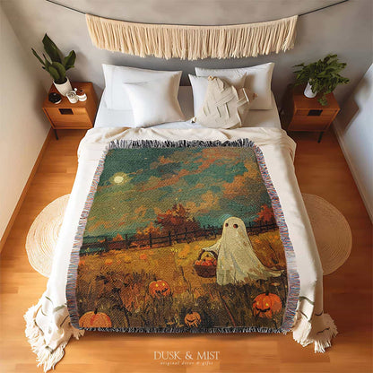 Woven cotton blanket depicting a ghost carrying a basket in a pumpkin-filled autumn field under a twilight sky.  