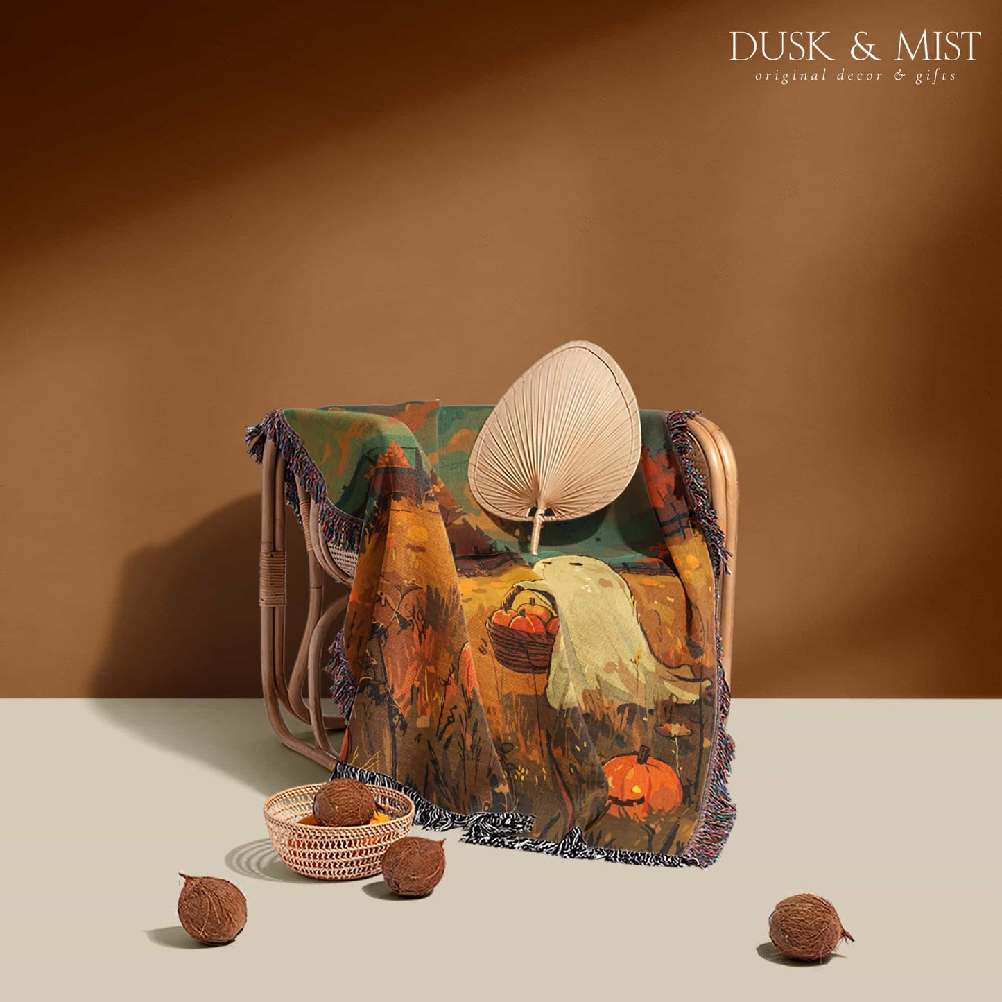 Woven cotton blanket depicting a ghost carrying a basket in a pumpkin-filled autumn field under a twilight sky.  