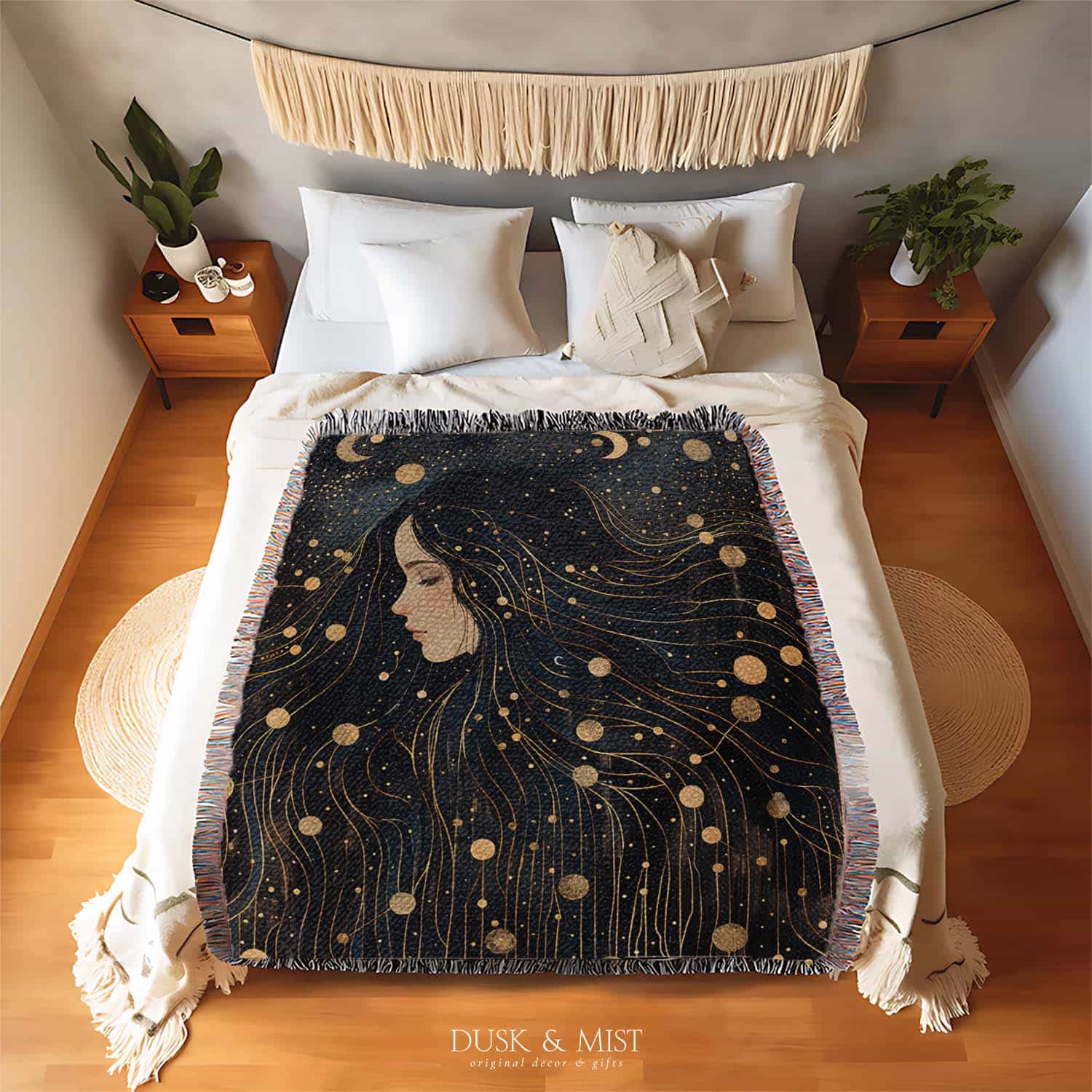 Woven cotton blanket featuring a profile of a woman with flowing hair illustrated as starry constellations, accented with golden moons and celestial motifs on a dark background.