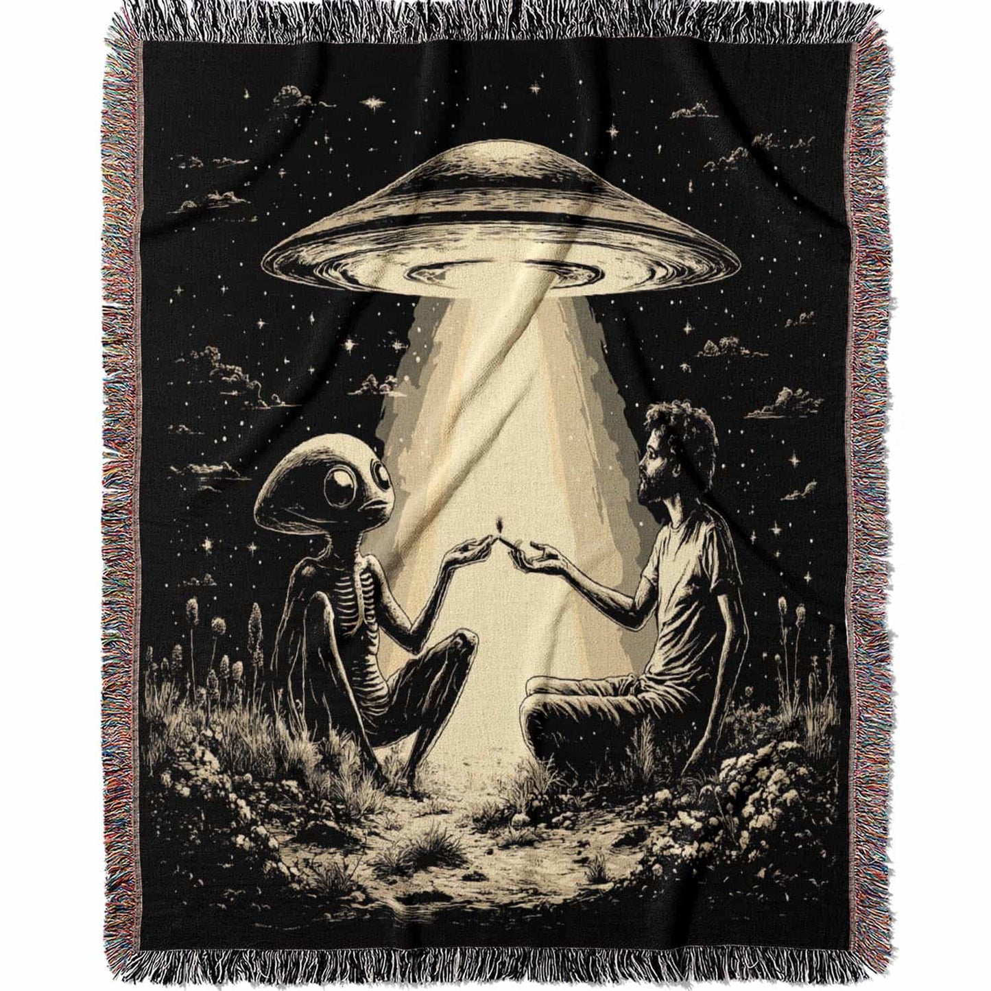 Woven cotton blanket featuring an alien and a human seated under a UFO’s glowing beam, reaching hands toward each other against a starry night sky.