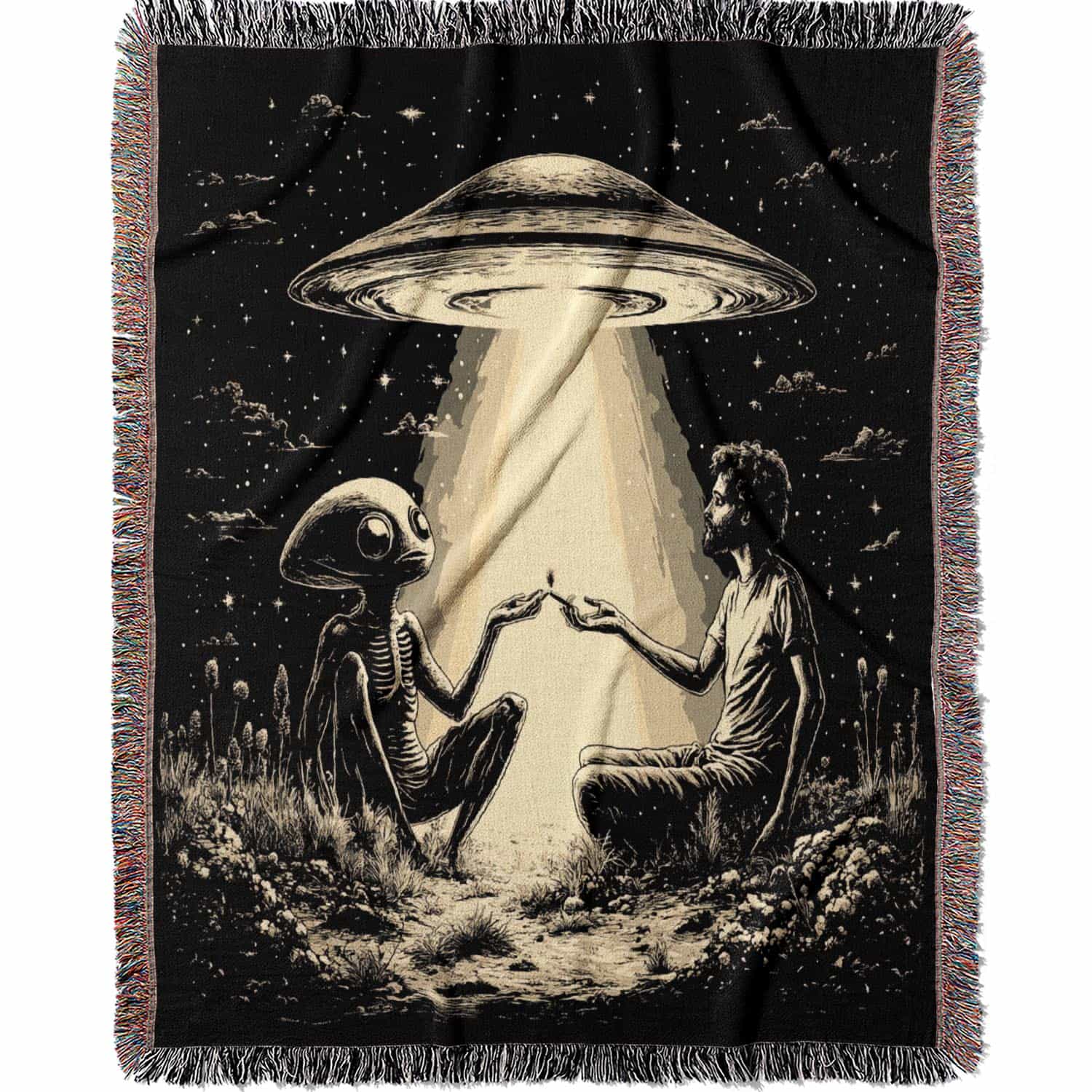 Woven cotton blanket featuring an alien and a human seated under a UFO’s glowing beam, reaching hands toward each other against a starry night sky.
