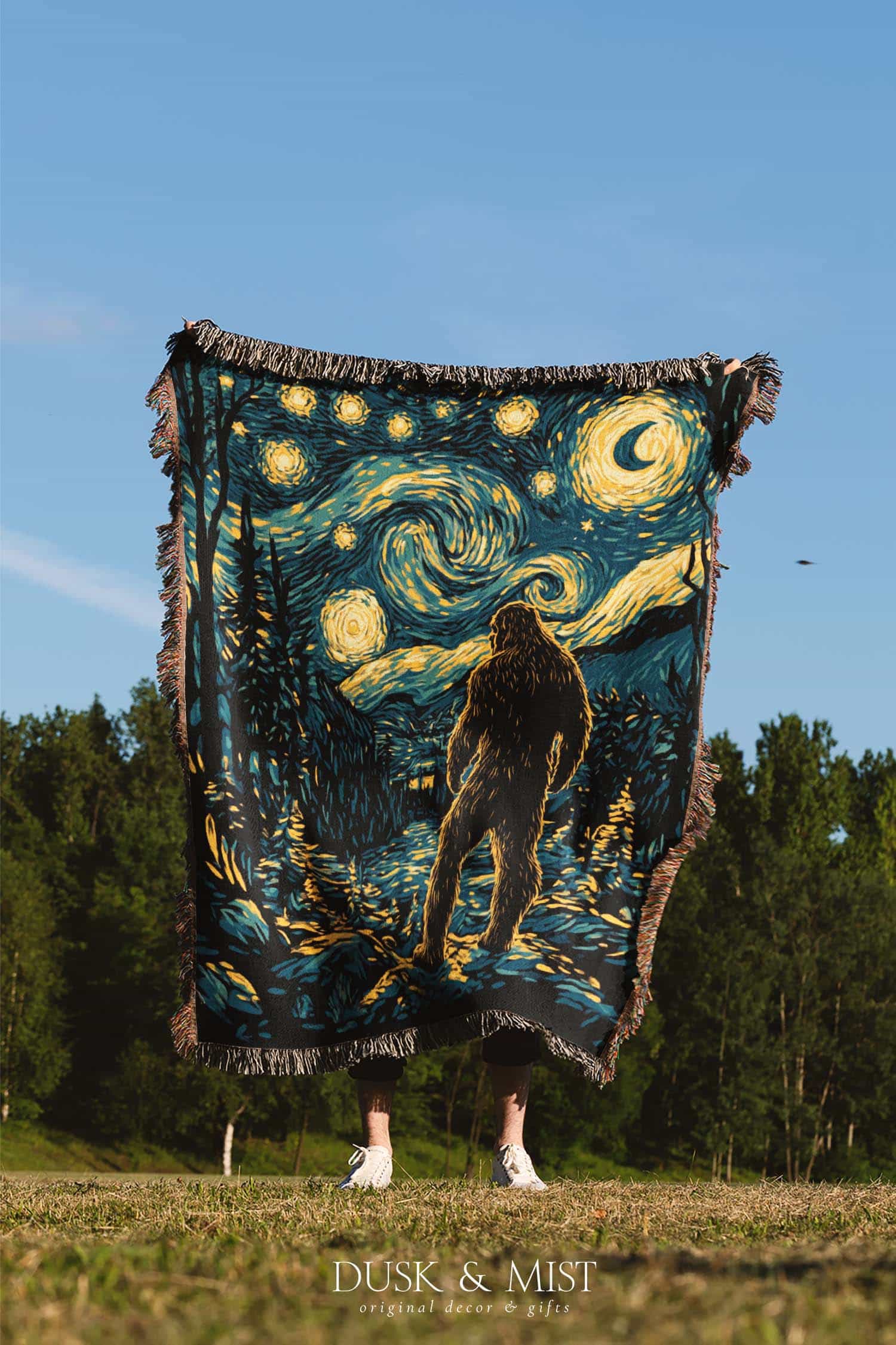 Woven cotton blanket featuring Bigfoot in a forest beneath a Van Gogh-style starry night sky with swirling constellations and moonlight.