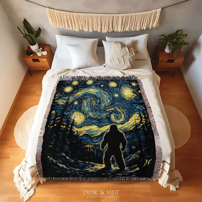 Woven cotton blanket featuring Bigfoot in silhouette against a Van Gogh-style starry night sky with swirling golden stars and dark forest trees.