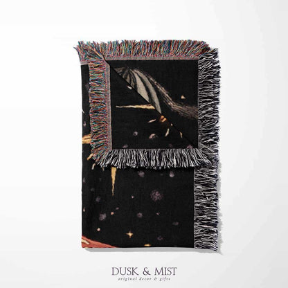 Woven cotton blanket featuring tall red-capped mushrooms under a starry sky with golden stars and surrounding plants on a black background.