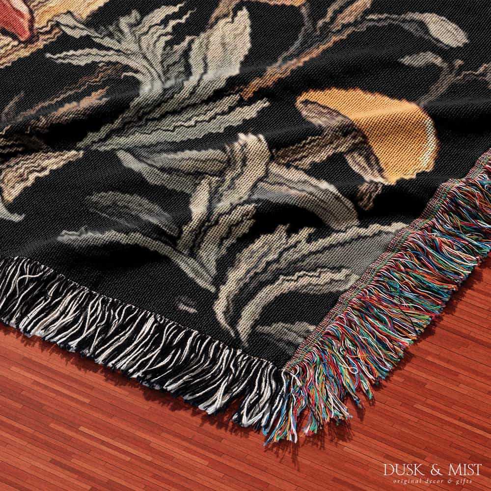 Woven cotton blanket featuring tall red-capped mushrooms under a starry sky with golden stars and surrounding plants on a black background.