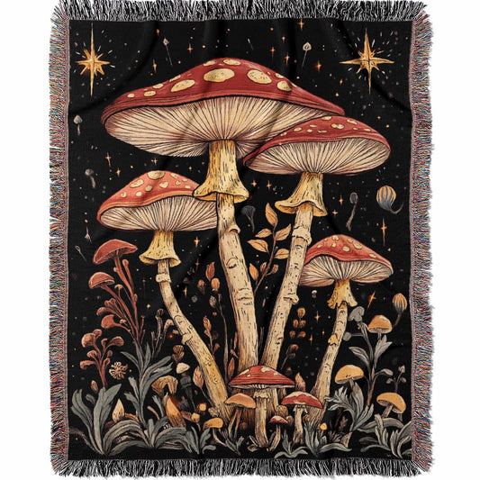 Woven cotton blanket featuring tall red-capped mushrooms under a starry sky with golden stars and surrounding plants on a black background.