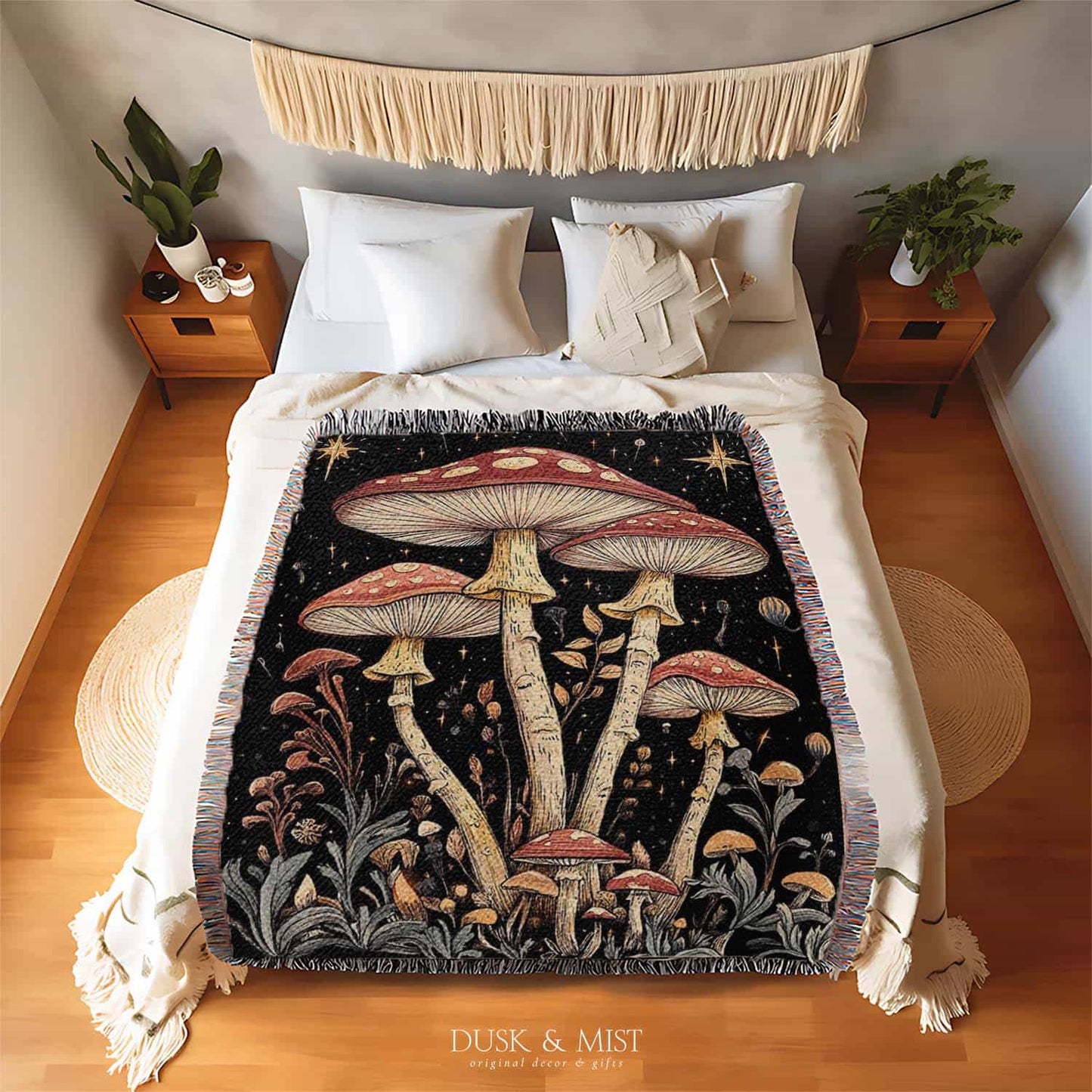 Woven cotton blanket featuring tall red-capped mushrooms under a starry sky with golden stars and surrounding plants on a black background.