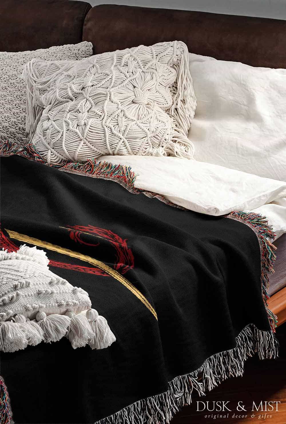 Woven cotton blanket featuring a red dragon wrapped around a golden sword on a black background with intricate wing and scale details.