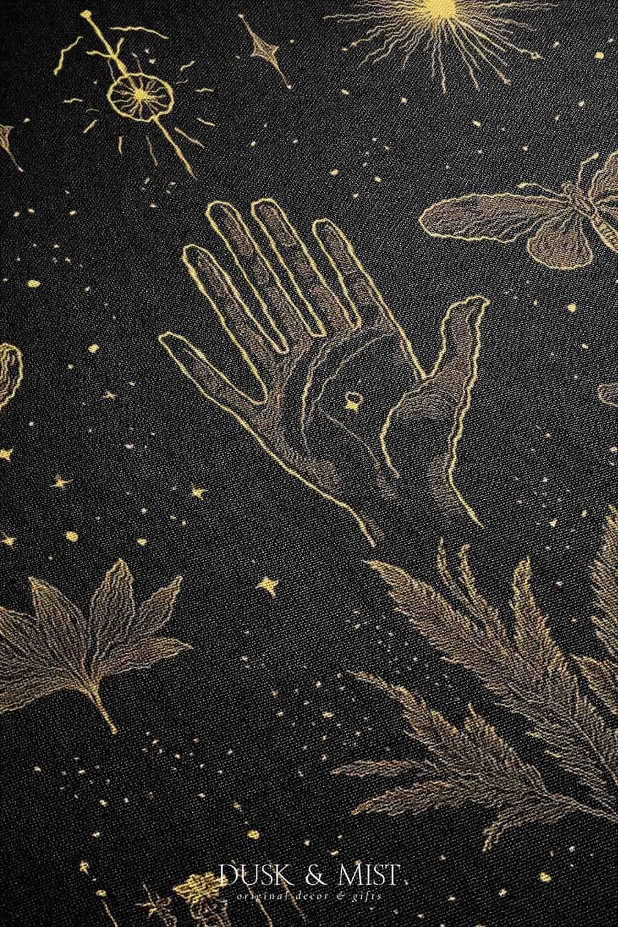 Woven cotton blanket with golden occult illustrations — palmistry hand, crescent moon, moth, snake, crystals, plants, and celestial symbols on a black background.