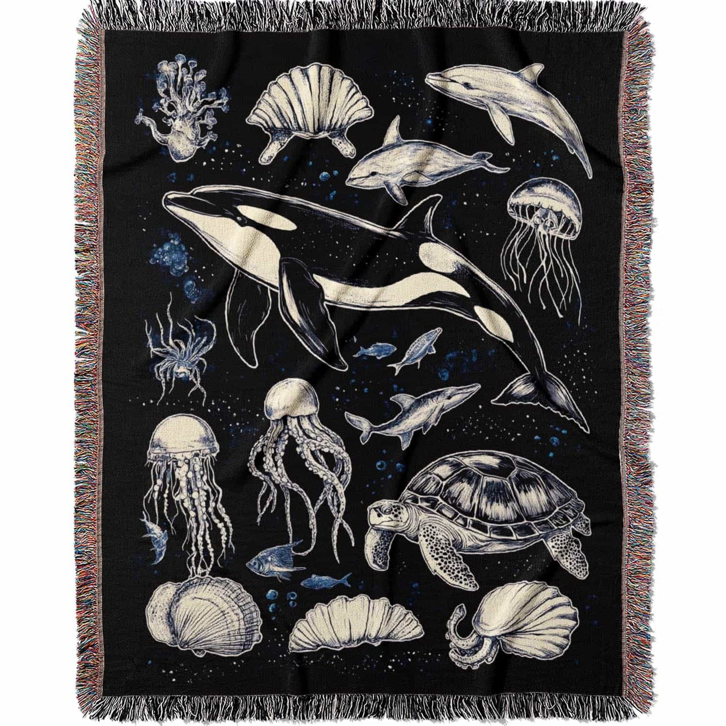 Woven cotton blanket featuring detailed marine life illustration — orca, dolphins, sea turtle, octopus, jellyfish, seashells, and fish on a black background.