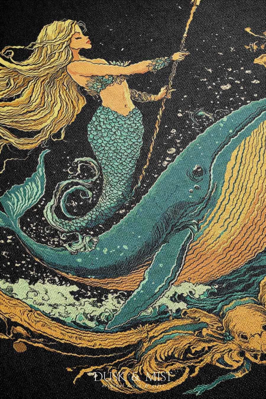 Woven cotton blanket featuring a warrior mermaid with flowing hair riding a whale, holding a spear, surrounded by ornate golden oceanic patterns.
