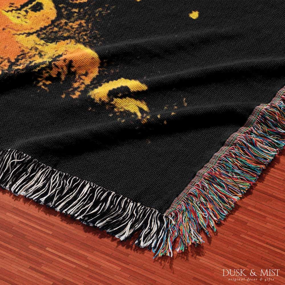 Woven cotton blanket featuring a UFO casting a golden beam into the forest at night, with glowing clouds and cosmic light effects.