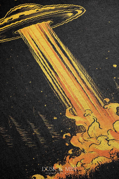 Woven cotton blanket featuring a UFO casting a golden beam into the forest at night, with glowing clouds and cosmic light effects.