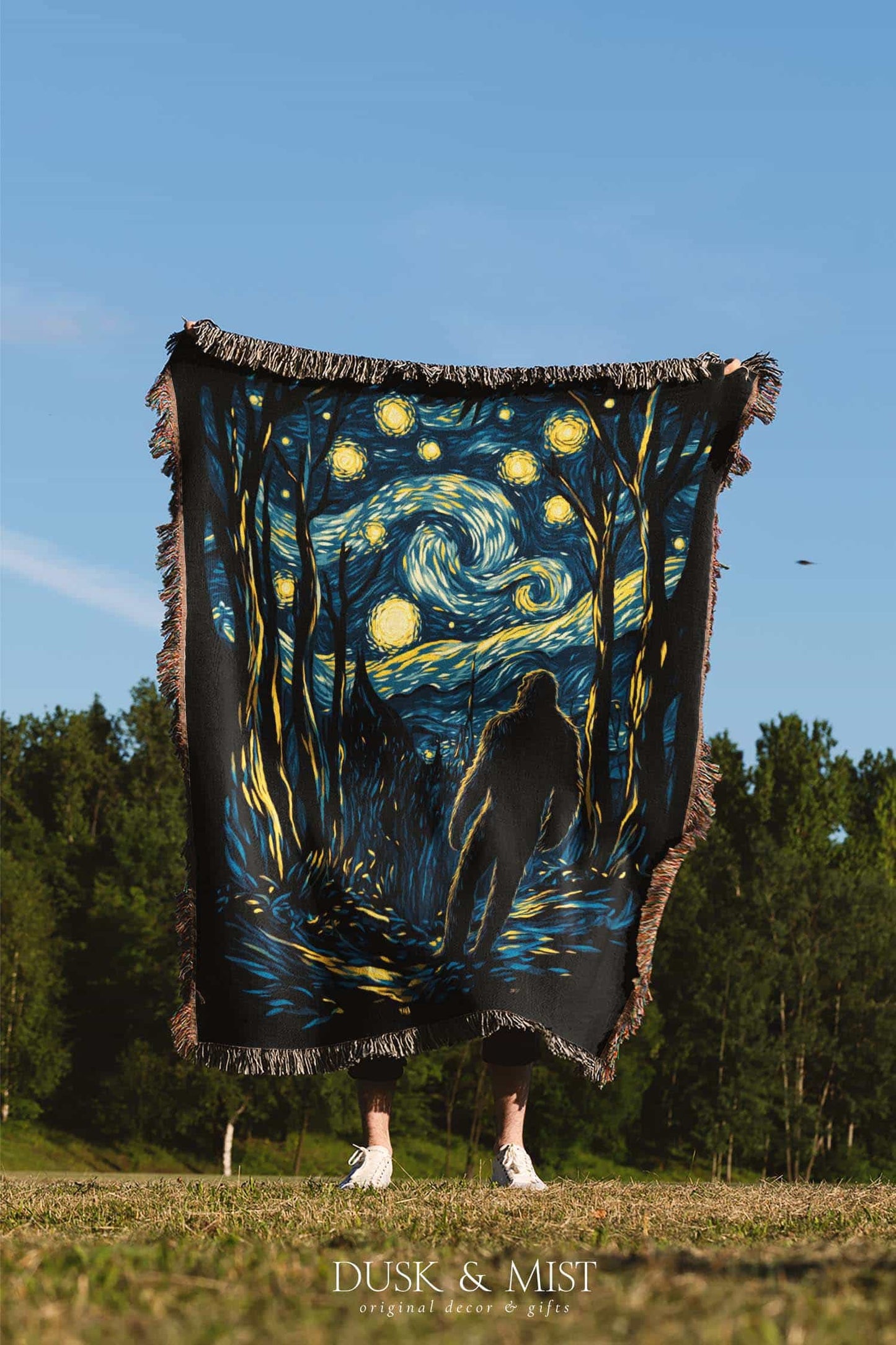 Woven cotton blanket featuring Sasquatch walking through a forest under a Van Gogh-style starry night sky with swirling stars and moonlight.