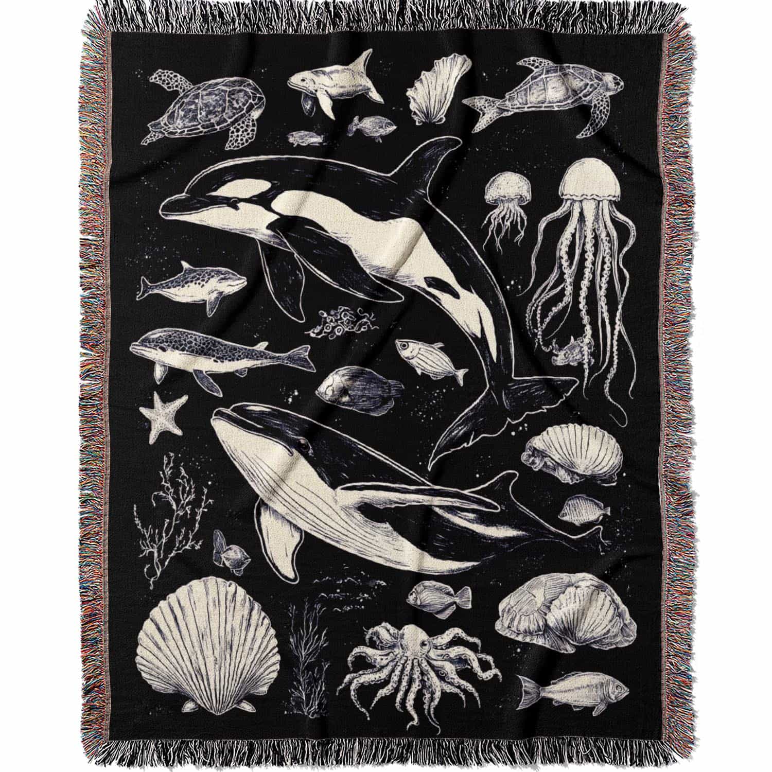 Woven cotton blanket featuring detailed ocean life illustration — whales, orca, turtles, jellyfish, octopus, seashells, fish, and coral on a black background.
