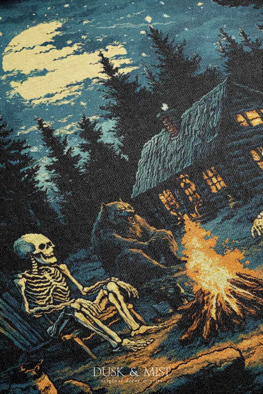 Woven cotton blanket showing two skeletons sitting around a campfire with a bear, log cabin, and full moon in a forest night scene.