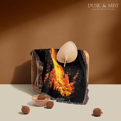 Woven cotton blanket featuring a UFO with a fiery orange beam illuminating a dark forest, with glowing clouds and night sky details.