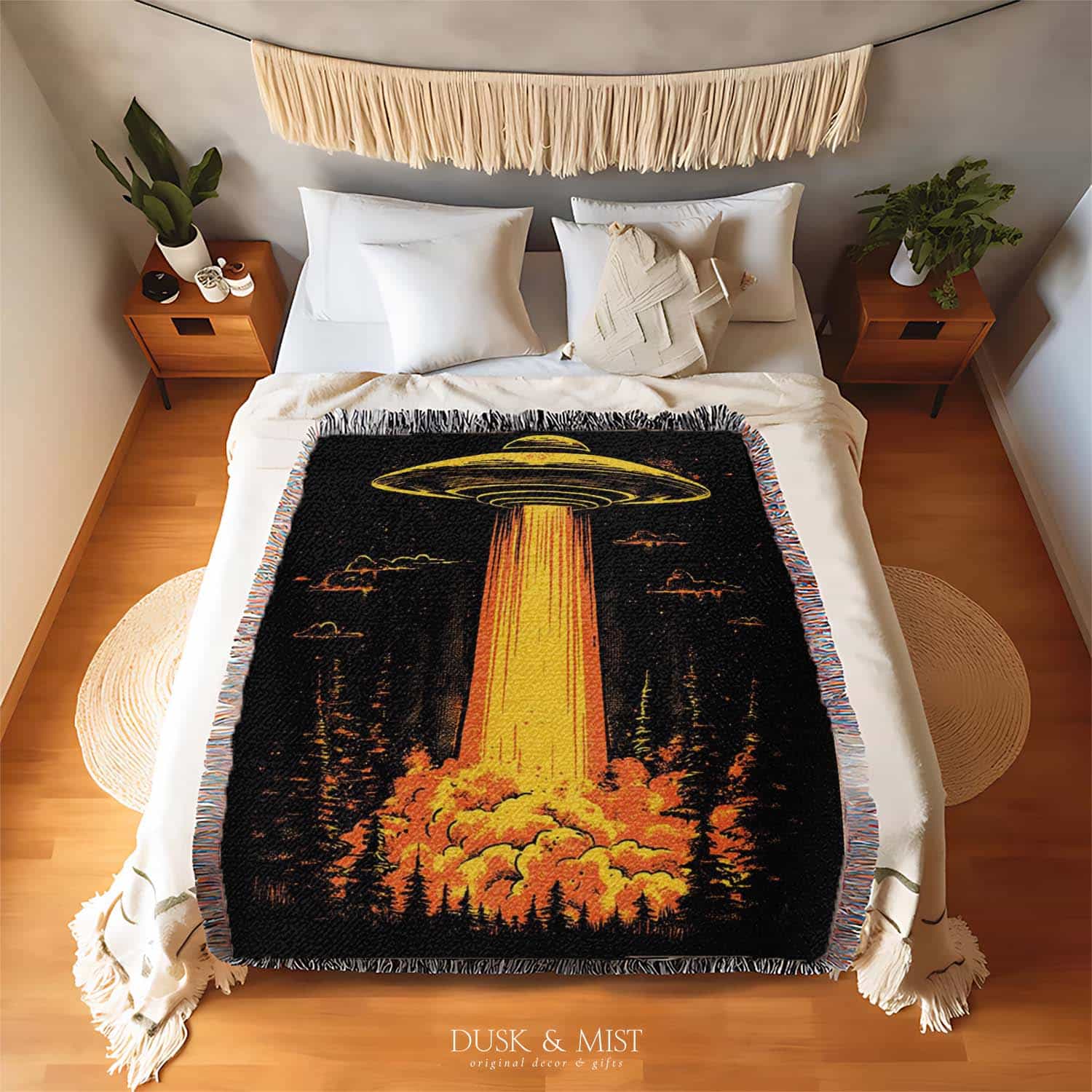 Woven cotton blanket featuring a UFO with a fiery orange beam illuminating a dark forest, with glowing clouds and night sky details.