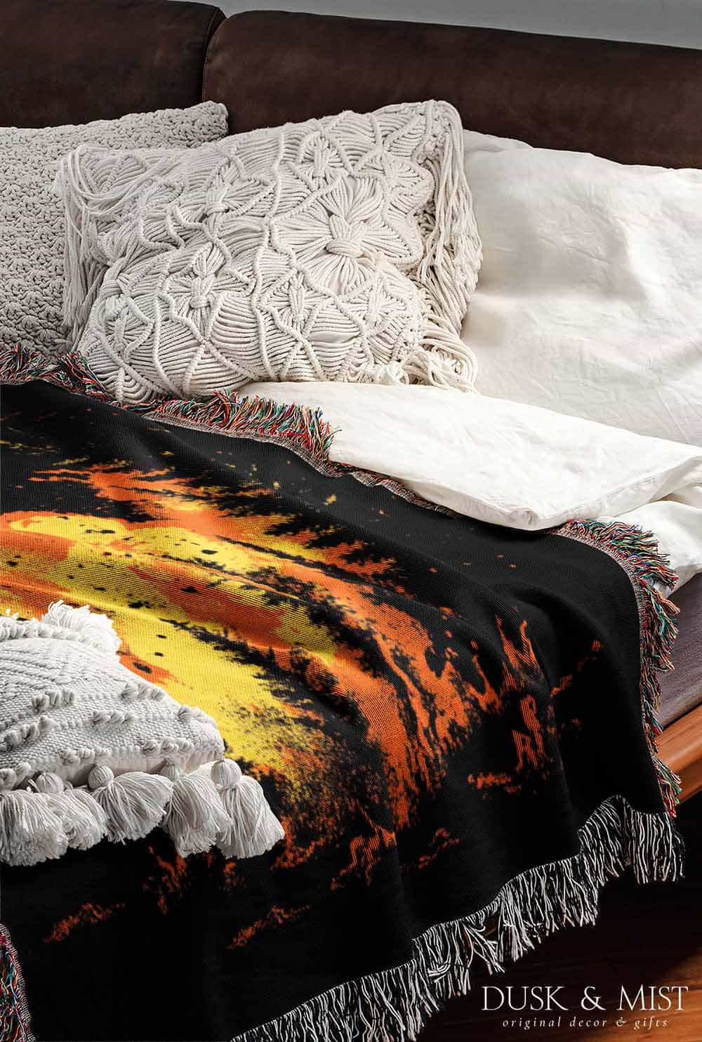 Woven cotton blanket featuring a UFO with a fiery orange beam blasting into a dark forest, with glowing explosions and cosmic night details.