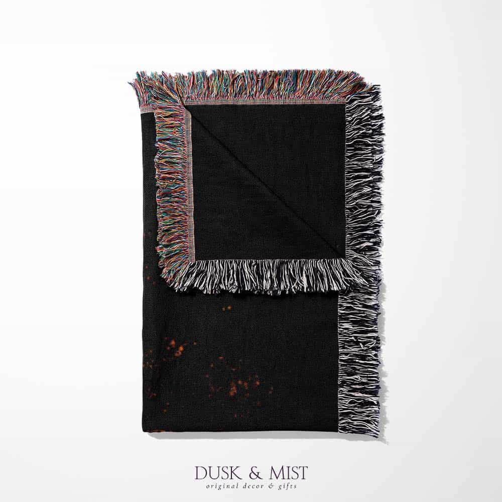 Woven cotton blanket featuring a UFO with a fiery orange beam blasting into a dark forest, with glowing explosions and cosmic night details.