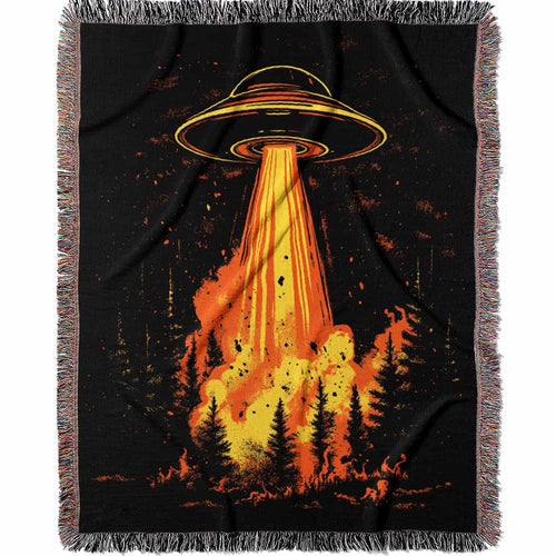 Woven cotton blanket featuring a UFO with a fiery orange beam blasting into a dark forest, with glowing explosions and cosmic night details.