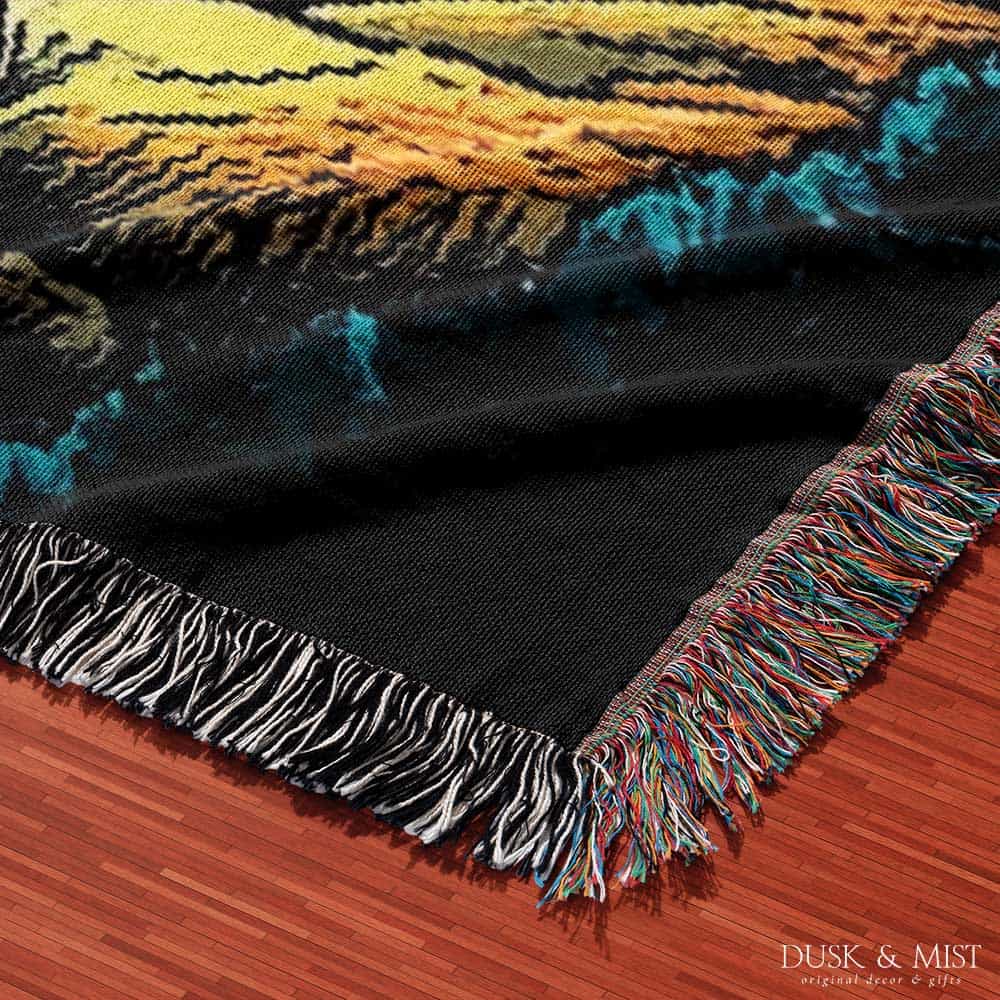 Blanket with a UFO abduction of a cow design against a starry night sky.